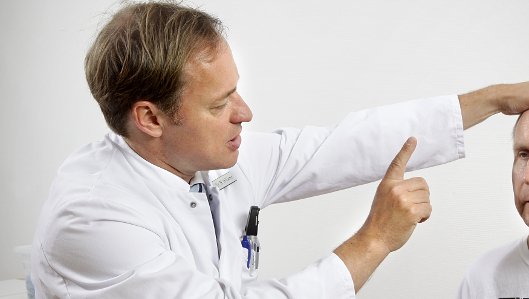 Prof. Dr. med. Rüdiger Hilker-Roggendorf bei der Untersuchung eines Patienten 